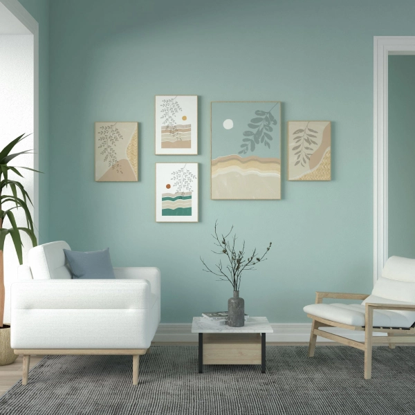 A serene living room features a collection of five abstract wall paintings with botanical and landscape themes in muted blues, greens, and beige tones.