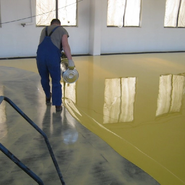 A Man Painting A Floor in Yellow Color