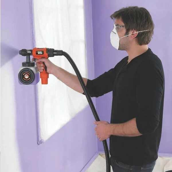 A Man Painting A Purple Color Wall With Spray in Dubai