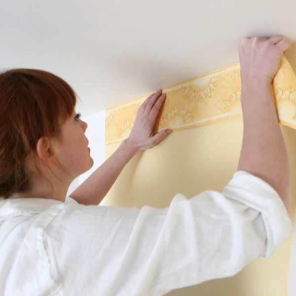 A beautiful girl applying a wallpaper in Dubai